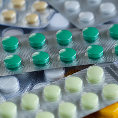pile of multi-colored round tablets in blisters