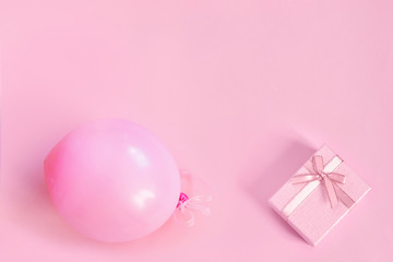 Pink ball and gift box with ribbon on paper background.
