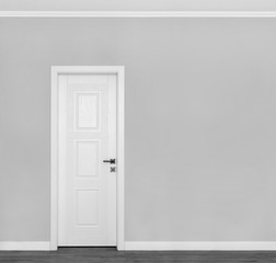 Beautiful wooden white door on empty grey wall with copy space for your text.