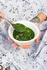 Green herbs spinach pesto sauce, paste or spread. Woman hands