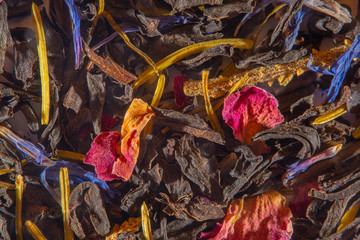 Background with scattered ready-made mixture with dry herbs for fruit and flower tea at high magnification