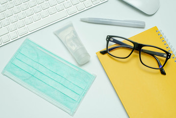 mask and Hand sanitizer alcohol on white table work space, work from home, Corona virus protection