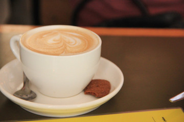 Amsterdam, Netherlands - July 12 2018: Coffee cup with cookie and spoon on a restaurant table