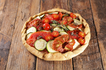 vegetable quiche with rosemary on wood background