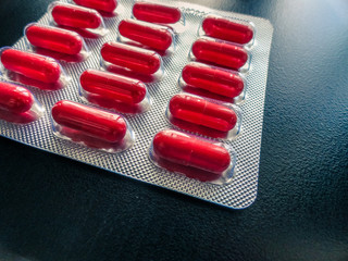 Photo of orange pills on a dark background.