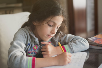 Seven years old girl doing homework at home