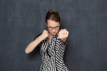 Portrait of focused dissatisfied young blond woman making punch