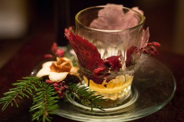christmas candle in glass with autumn leaves