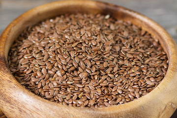 Flax seeds in a wooden bowl. Close up