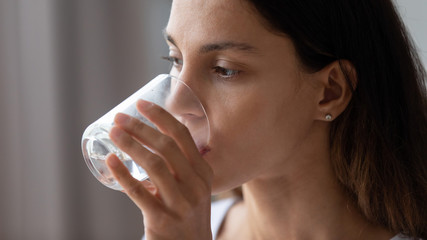 Close up exhausted thirsty woman drinking pure clean mineral water, dehydrated girl with perfect...