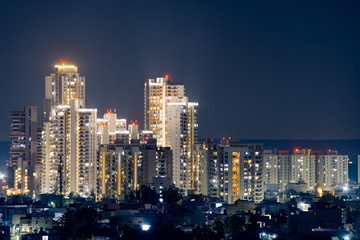 Fototapeta na wymiar cluster of sky scraper buildings at night with golden lights shot on a pollution free night in gurgaon delhi