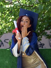College graduate in graduation clothes with diplomas in their hands.Young girl in prom clothes.