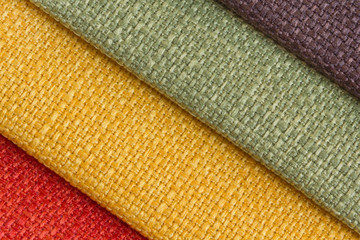A set of colored samples of upholstery fabric for furniture in stock. Background from rolls of...