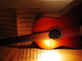 Close-up Of Guitar On Sheet Music