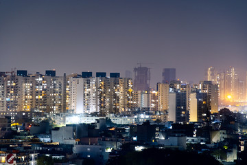 Aerial panorama shot of buildings skyscrapers with offices and residences with lights on at night
