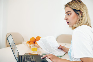 Young woman working from home at kitchen table.