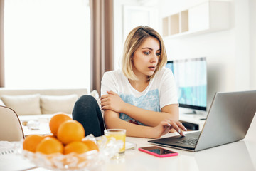 Young woman working from home at kitchen table.