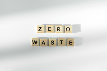 Zero waste text written by wooden letters on white background. Flat lay, top view.