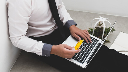 Business man is holding credit card and using notebook for shopping online.