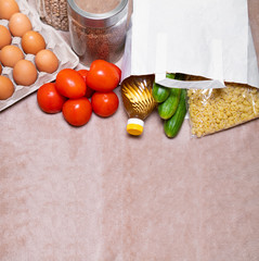 Food donations: fresh vegetables, chicken eggs, pasta, butter and cereals, top view