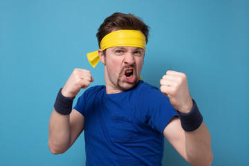 Handsome young caucasian man in fighting position holding fists up.