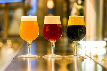 Three kinds of beer, blonde, red and black in a pub
