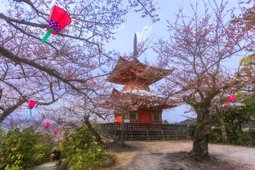 Fototapeta premium Historical five-story pagoda of Toyokuni Shrine and a typical Japanese roof in Miyajima, Hiroshima, Japan