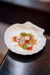 Scallop with tomatoes and sauce and basil