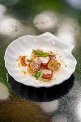 Scallop with tomatoes and sauce and basil