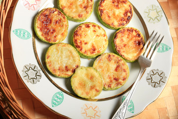 Homemade Fried sliced courgette. Zucchini cut into pieces served on plate or bowl on wicker wooden table. Vegetable vegetarian food dish close-up