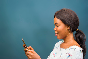Obraz premium young beautiful african lady feeling excited about the transaction she carried out her cellphone, mobile phone, phone and holding her credit card