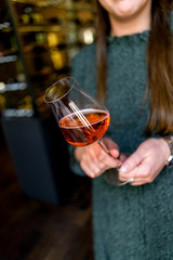 Woman hand with glass of rose wine cafe bar bokeh
