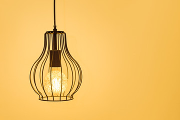 modern interior lamp with a retro lamp on a yellow background, the concept of home comfort and interior