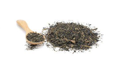 Pile of dry green tea leaves with piece of wooden spoon isolated on white background.