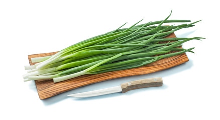 fresh green onion stems on wooden chopping board and kitchen knife isolated