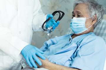 Doctor help Asian senior or elderly old lady woman patient wearing a face mask in hospital for...