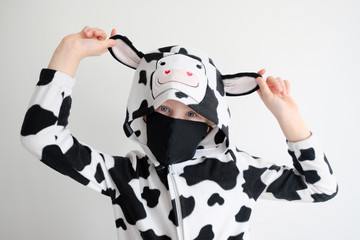 little girl in animal pajamas and protective face mask. Pajana Cow Wearing A Baby