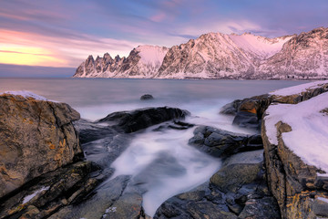 Fototapeta na wymiar The rocky beach and pools at sunset on Ersfjord. Senja island in the Troms region of northern Norway. Long exposure shot