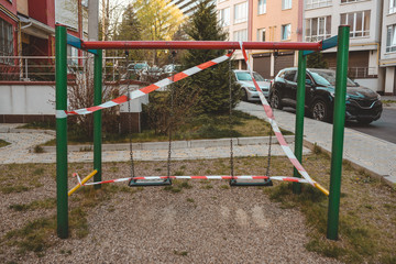 Fototapeta na wymiar Playground wrapped in striped red white tape, stay home. Quarantine area for sports, prevention of infection with the covid-19 coronavirus influenza virus. no people
