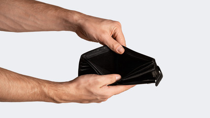 Coronacrisis and bankruptcy. Closeup of businessman holding empty wallet on white background, panorama