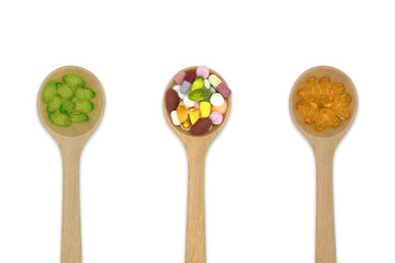 Top view Variety of vitamin and mineral pills oil filled capsules (soft gel) in wooden spoon isolated on white background, Dietary supplement healthcare product Clipping path.