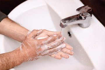 washing hands with soap in a washbasin