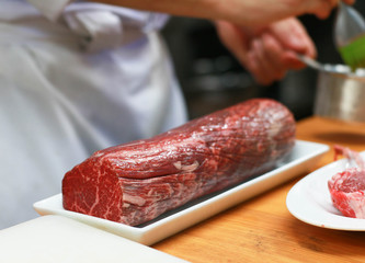 Big raw boneless beef steak meat on a white plate.