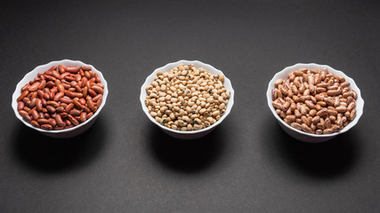 Assortment beans in round bowls on black background