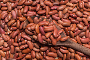 Dried red beans on a rustic wooden spoon