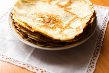 pancakes on a white tablecloth and plate a sunny day with sun glare