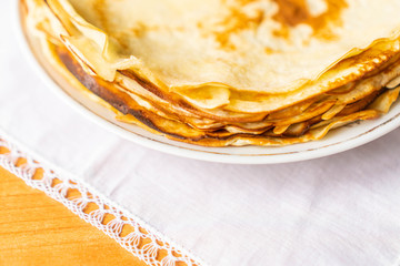 pancakes on a white tablecloth and plate a sunny day with sun glare