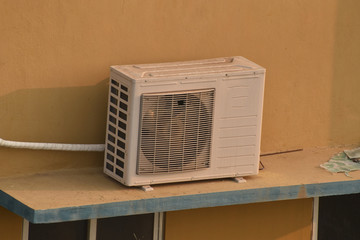 Air conditioner outdoor unit which is known as compressor is installed on the sun shade of the building. in india