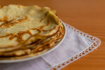 pancakes on a white tablecloth and plate a sunny day with sun glare