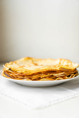 pancakes on a white tablecloth and plate a sunny day with sun glare